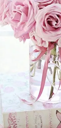 This live phone wallpaper features a charming arrangement of pink roses in a glass vase on top of a stack of books