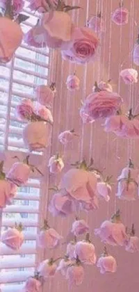 This phone live wallpaper presents a beautiful collection of pink roses hung from a window, blowing in the wind