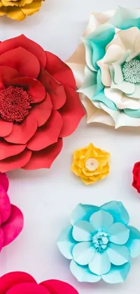 This live phone wallpaper features a beautiful collection of paper flowers in trending red, teal, and yellow colors