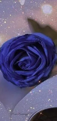 This live wallpaper showcases a mystical blue rose perched on a vintage book with turning pages