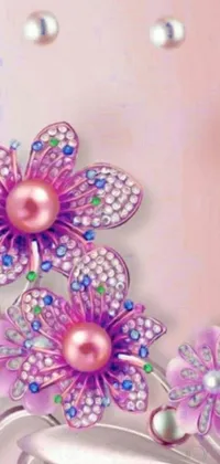 Decorate your phone screen with this stunning digital art live wallpaper featuring a cell phone adorned with beautiful flowers and sparkling jewels in shades of pink and purple