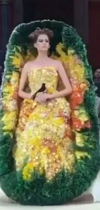 This stunning live wallpaper features a regal woman seated on a flower chair and wearing a mage robe with a toucan-inspired design made of fruit and flowers
