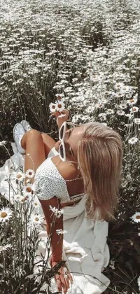 Enhance your phone's aesthetic with this lively wallpaper of a woman immersed in a lush field of daisies