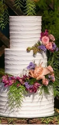 This stunning phone live wallpaper shows a close-up shot of a beautifully decorated white wedding cake on display at a reception