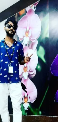 This live wallpaper displays hyperrealistic artwork featuring a man standing in front of a wall embossed with floral patterns, an album cover, an orchid, and a neon cityscape