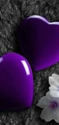 This phone live wallpaper features a stunning design with two purple hearts and a white flower