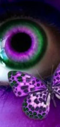This live phone wallpaper boasts a captivating close-up of a person's eye with a butterfly perched on it, shining in vibrant shades of purple and green