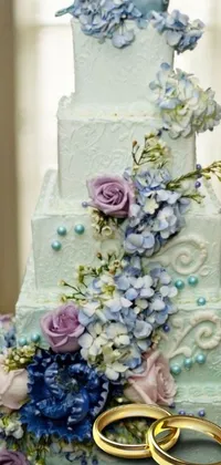 This stunning live wallpaper showcases a close-up of a beautiful wedding cake, complete with two golden rings