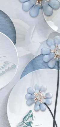 Enhance the look of your phone with this stunning live wallpaper! Featuring intricately designed flowers and delicate butterflies on a plate, the image is rendered in soft white and pale blue tones
