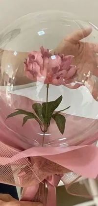 Enjoy a beautiful live wallpaper featuring a charming glass vase filled with a delicate pink flower