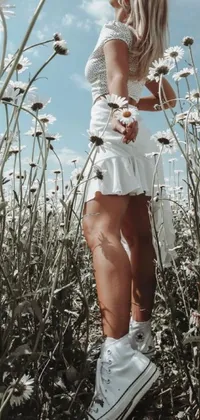 This phone live wallpaper features a beautiful and serene natural scene with a woman standing among a field of white daisies