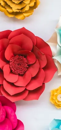 This live phone wallpaper showcases a captivating image of paper flowers arranged on a table with exquisite details