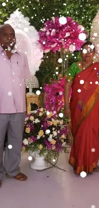 This elegant live wallpaper features a man and woman standing in front of a lovely floral display