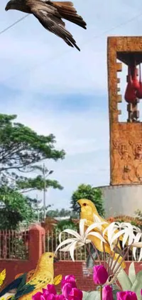 This live phone wallpaper features a bird flying amid a bed of vibrant flowers against a backdrop of an album cover, a statue, and a village square with yellow cloths