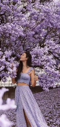This lively phone live wallpaper features a woman under a tree with purple flowers