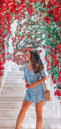 This phone live wallpaper features a stunning woman standing in front of a beautiful bunch of red flowers