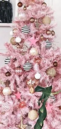 This live phone wallpaper features a pink Christmas tree with black and white ornaments, surrounded by pastel decor and fairy lights