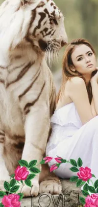 This phone live wallpaper showcases a mesmerizing image of a beautiful woman and a white tiger sitting on a rock, surrounded by colorful flowers in the background