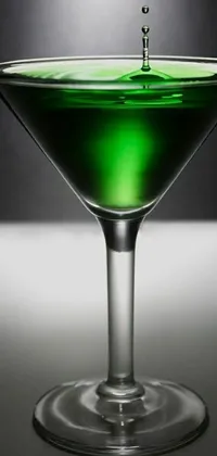 This phone live wallpaper features a captivating design with a green liquid pulsing in a glass against a striking black background