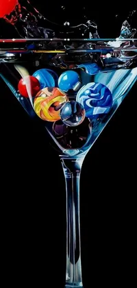 This phone live wallpaper features a mesmerizing display of a martini glass filled with vivid marbles on a blue marble background