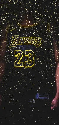 Looking for a basketball-themed live wallpaper perfect for sports enthusiasts? This phone wallpaper features a close-up of a cell phone held by someone wearing an NBA jersey, surrounded by a black armor with yellow accents