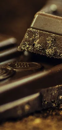 This live wallpaper depicts a still life scene of two pieces of chocolate placed on a table