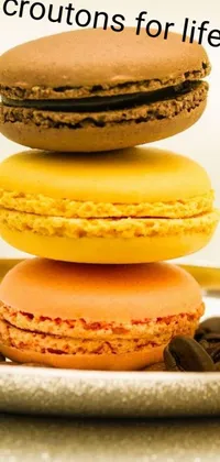 Indulge in a mouth-watering phone live wallpaper featuring three scrumptious macarons stacked on a brown plate