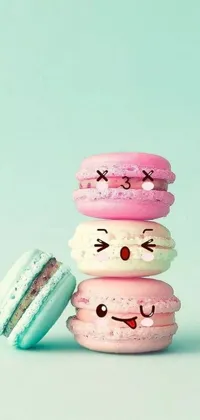 Looking for a cute and whimsical phone wallpaper? This live wallpaper features a stack of macarons in pastel blue and pink hues with cute faces drawn on them, perfect for those with a love for all things sweet and playful
