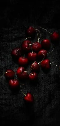 This stunning phone live wallpaper features a beautiful digital artwork of cherries arranged on a table