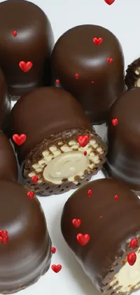 This unique phone live wallpaper showcases a delightful pile of chocolates tastefully displayed on a pristine white table
