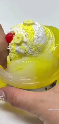 This lively phone live wallpaper features a striking close-up shot of a hand holding a cup of mouth-watering ice cream