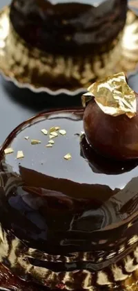 Get ready to satisfy your sweet tooth with this stunning phone live wallpaper! The image shows a close up of a scrumptious chocolate cake sitting on a golden plate