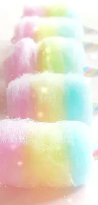 This live wallpaper showcases a row of colorful cotton candy perched on a table