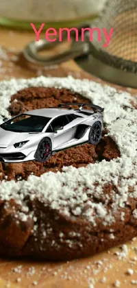 If you're looking for a unique and exciting live wallpaper for your phone, check out this design featuring a delicious cookie on a wooden table, a stunning photograph of a supercar racing through a desert, and a colorful cityscape in the background
