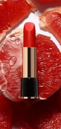 This stunning live wallpaper features a striking combination of a classic red lipstick perched atop a vibrant pile of grapefruits