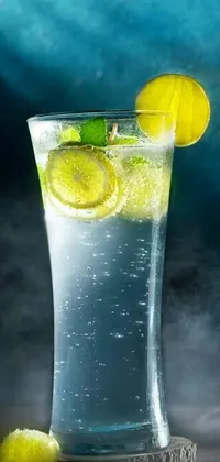 This phone live wallpaper features a glass of water with a lemon slice and a green leaf on the rim