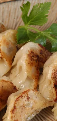 This phone live wallpaper depicts a plate of deliciously prepared dumplings arranged on a table