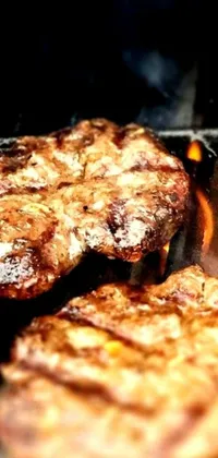 This phone live wallpaper showcases sizzling hamburgers on a grill with fiery flames, perfect for adding summertime vibes to your device