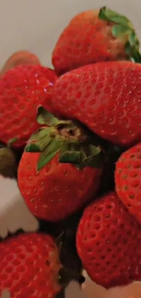 Indulge in the juicy sweetness of this phone live wallpaper featuring a bowl of photorealistic strawberries