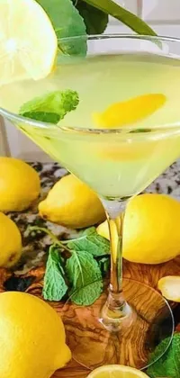 This phone live wallpaper features a refreshing glass of lemonade with slices of lemons and sprigs of mint, accompanied by scattered lemon rinds