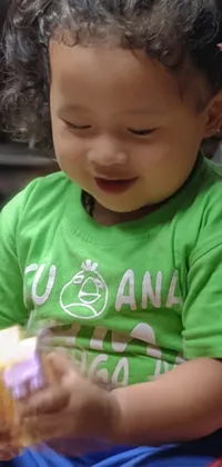 This live wallpaper features an adorable little girl sitting on the floor with a container of food in her lap