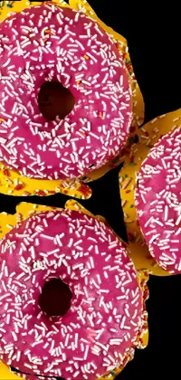 Get ready to indulge in sweetness with this live phone wallpaper! Featuring a stunning masterpiece work of art, this wallpaper showcases three scrumptious donuts with sprinkles on a black and yellow background