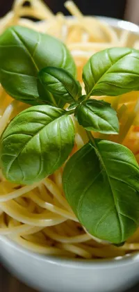 This live wallpaper for your phone features a stunning macro image depicting a bowl of white pasta adorned with a sprig of fresh basil