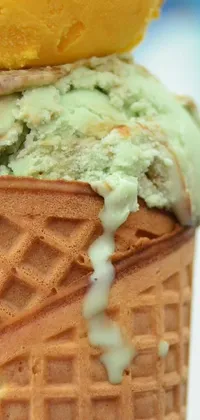 This phone live wallpaper depicts a colorful and mouth-watering scoop of ice cream resting on top of a waffle cone