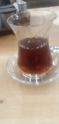 This phone live wallpaper features a cup of tea resting on a saucer on a table beside a picture