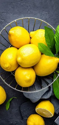 Looking for a refreshing live wallpaper for your phone? Look no further than this vibrant design featuring a basket of lemons and a knife against a deep black background