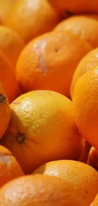 This phone live wallpaper showcases a pile of juicy oranges, arranged in a neat pile, and captured in high detail