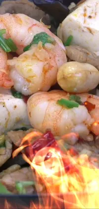 This live phone wallpaper showcases a sizzling plate of food being cooked over an open flame