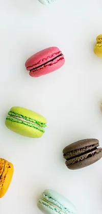This live phone wallpaper showcases a colorful arrangement of macarons resting on a white tabletop