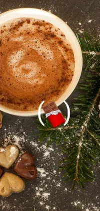 The phone live wallpaper showcases a cup of piping hot chocolate on a wooden table, perfect for the winter season
